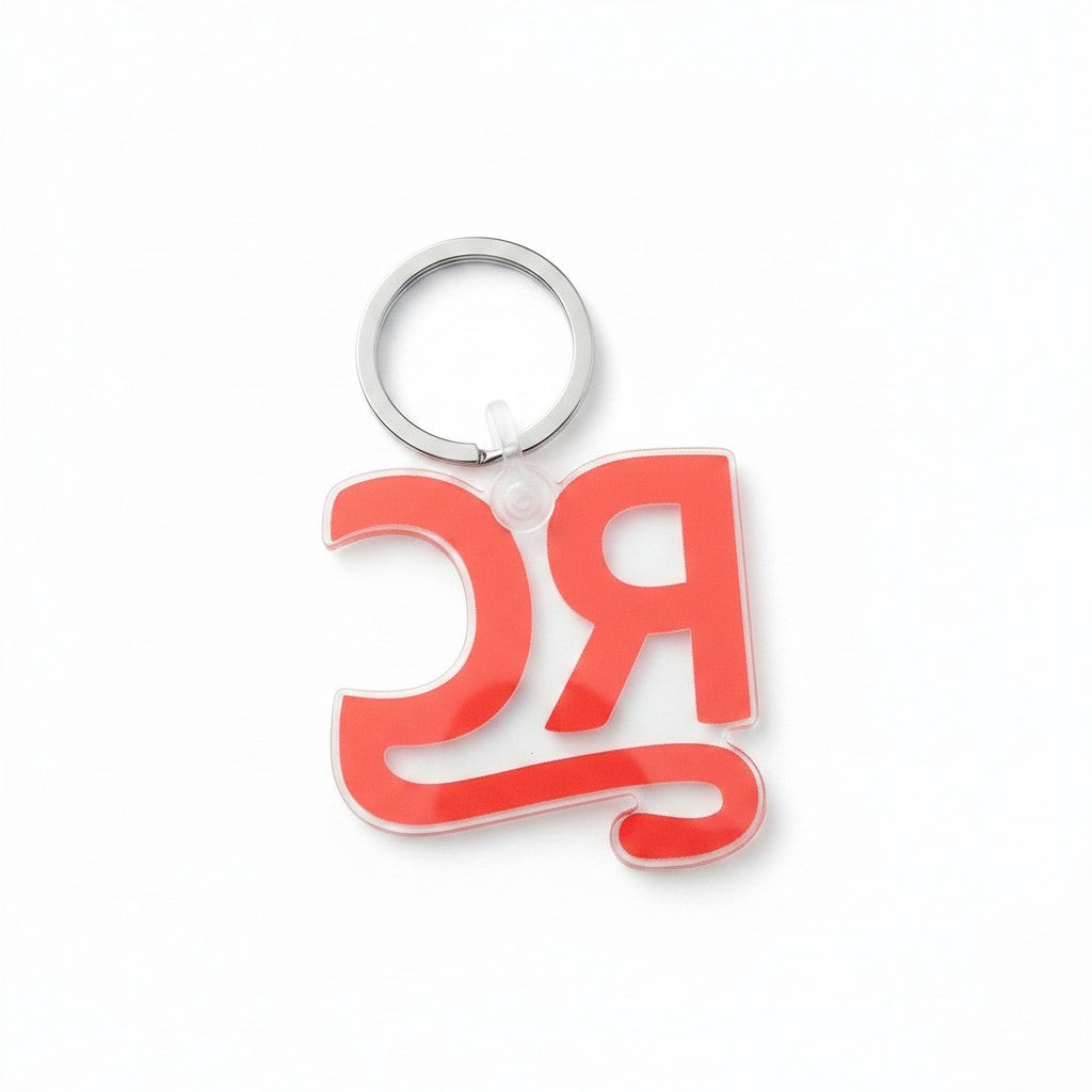 The RevenueCat Swag Store clear acrylic keychain with bold red RC monogram logo and metal split ring