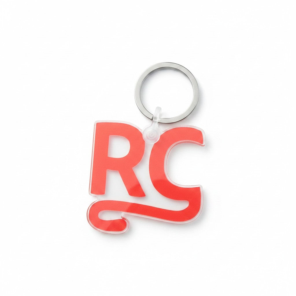 The RevenueCat Swag Store clear acrylic RC monogram keychain with bold red lettering and a sturdy metal split ring.