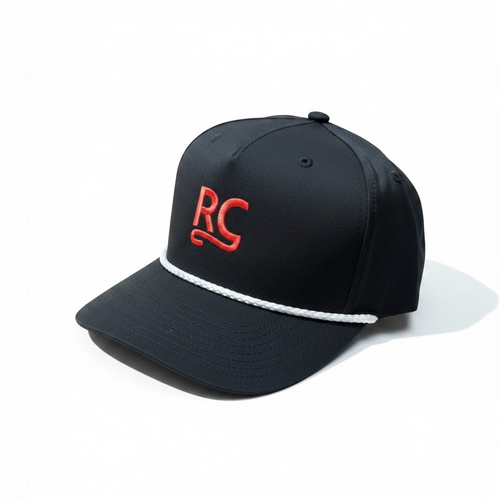 The RevenueCat Swag Store black structured snapback hat with a red embroidered RC logo and white braided rope detail.