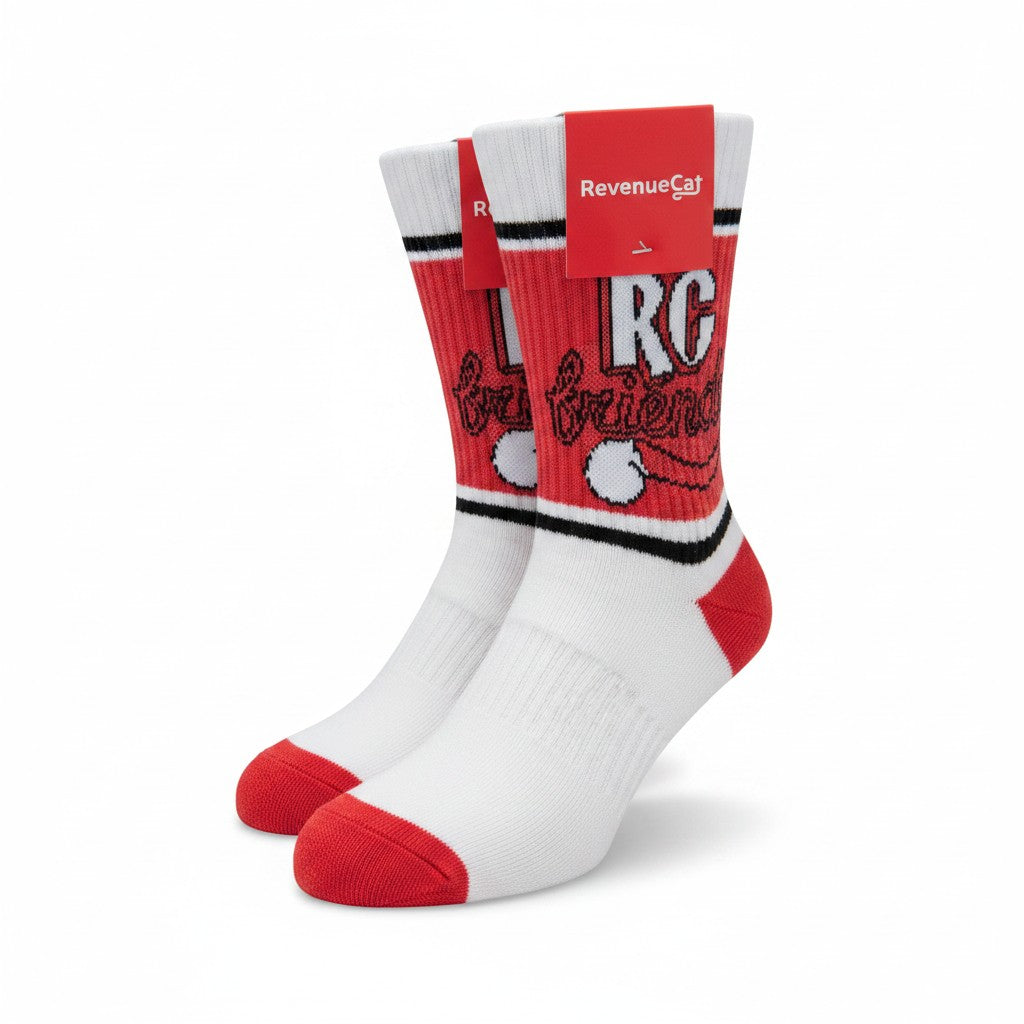 The RevenueCat Swag Store red and white crew socks featuring RC friends graphic and reinforced heel and toe.