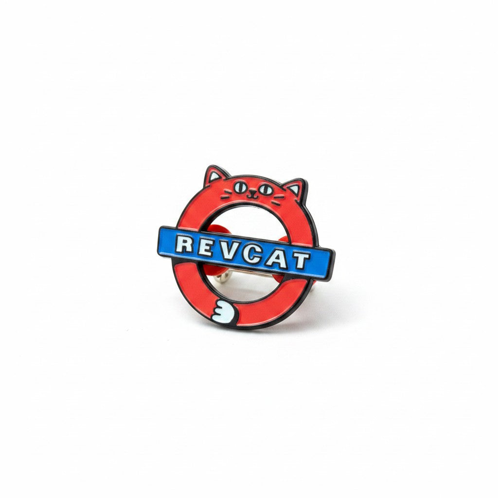 The RevenueCat Swag Store round enamel pin featuring a red cat design with a blue Revcat logo on a white background.
