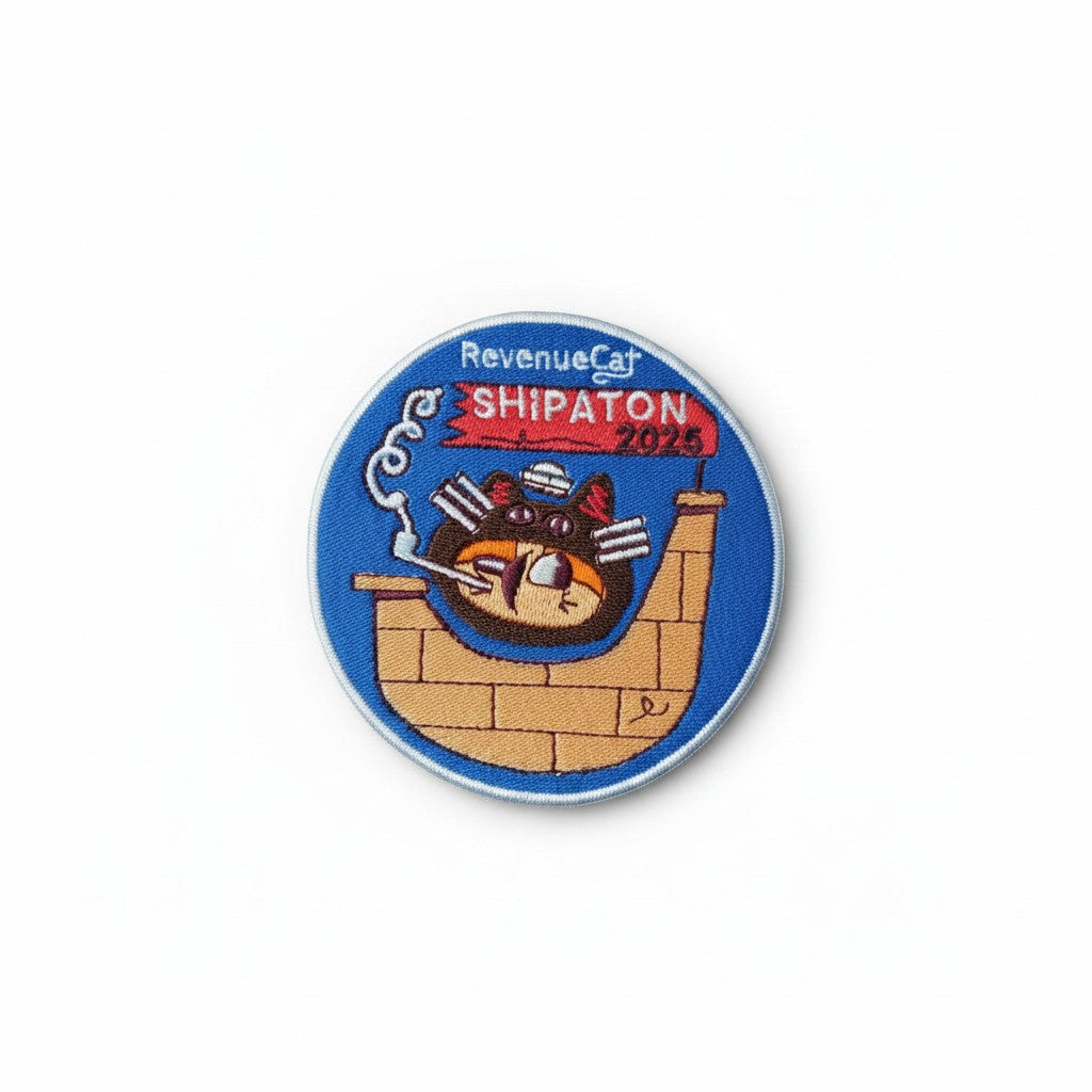 The RevenueCat Swag Store circular embroidered patch featuring a cat captaining a ship on a blue background.